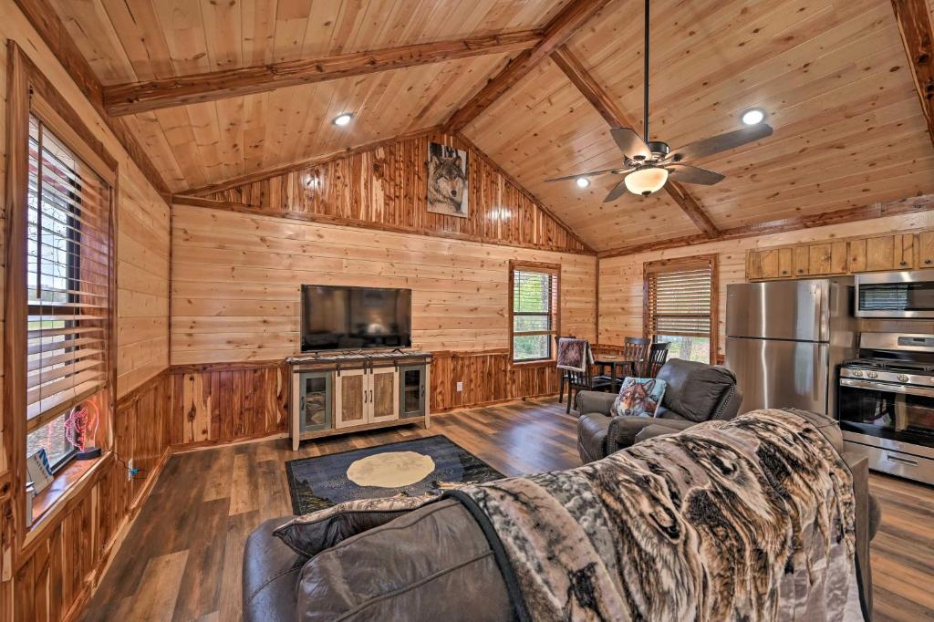 a living room with a couch and a tv at Cozy Broken Bow Cabin, Walk to the Lukfata Creek! in Broken Bow