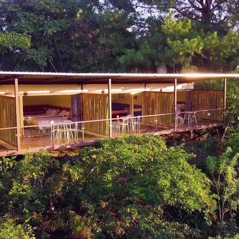 a house with a deck with tables and chairs at Hotel Pibi Boreal in Alajuela City