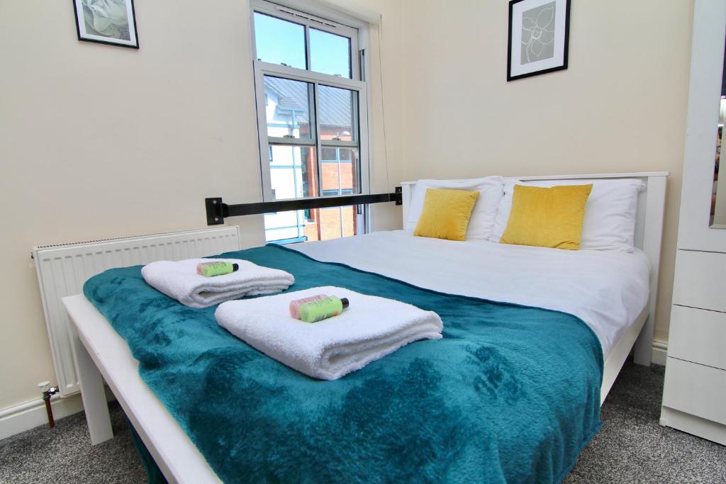 een slaapkamer met een groot bed en handdoeken bij Comfy Studio in the Heart of Coventry City Centre in Coventry