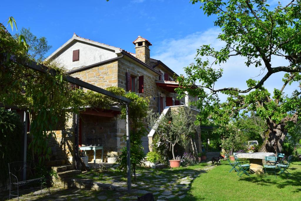 une vieille maison en pierre avec une cour devant elle dans l'établissement Apartman CASA MARŠIĆ, à Oprtalj
