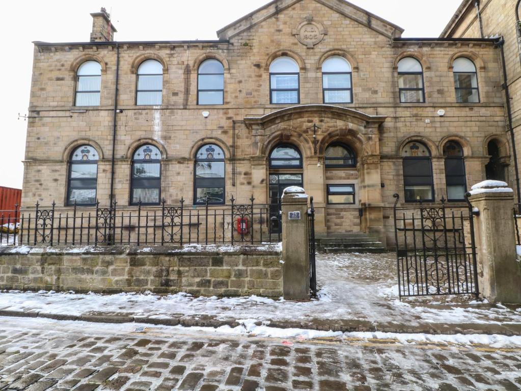 un edificio de ladrillo con una puerta delante de él en Apartment 24, en Keighley