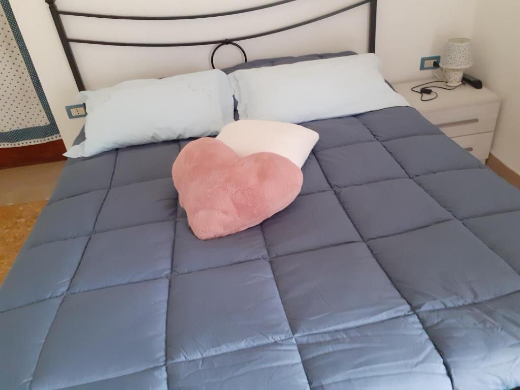 a pink heart pillow sitting on a blue bed at A casa di Adele in Caserta