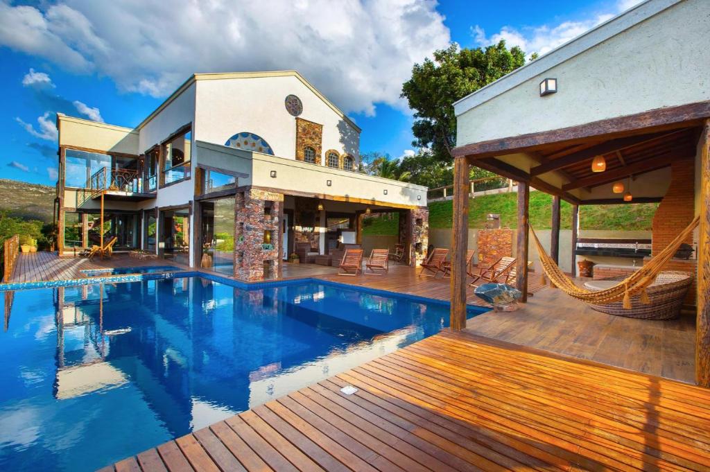 a large house with a swimming pool and a deck at Sitio Jatoba/Lapinha da Serra in Santana do Riacho