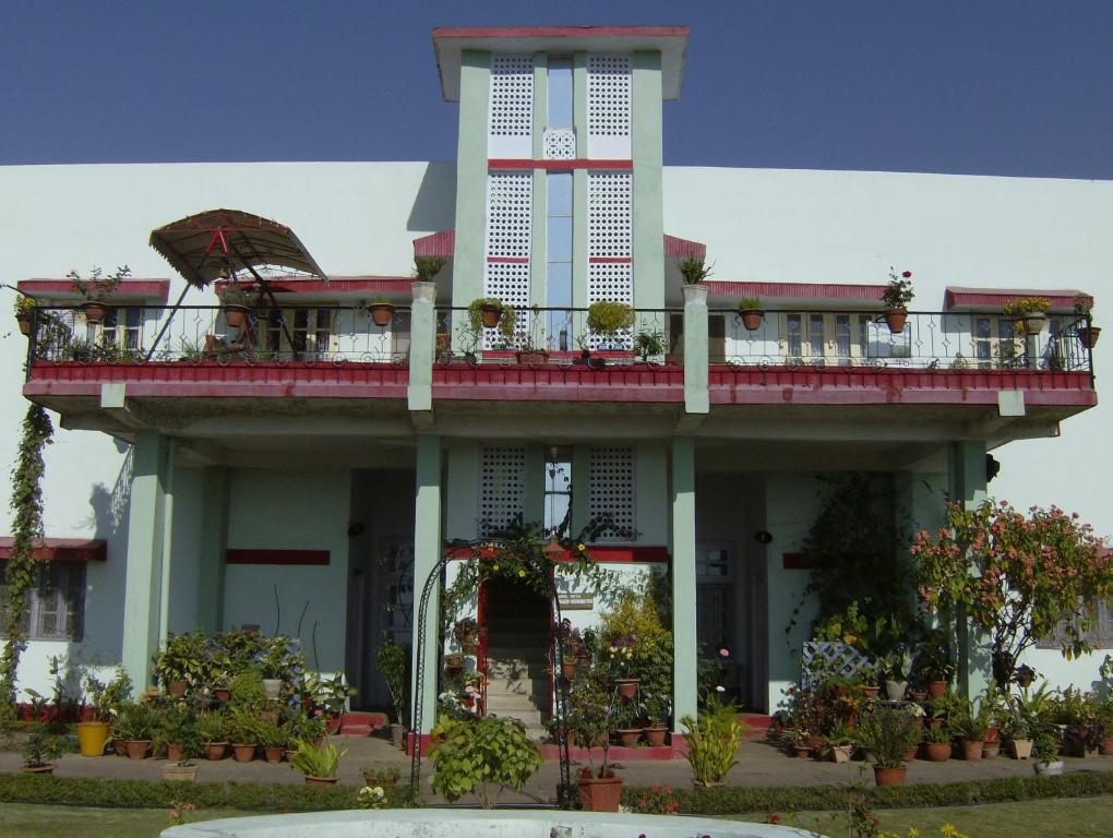 un edificio con un balcón con plantas. en Jheelam Homestay, en Bhopal