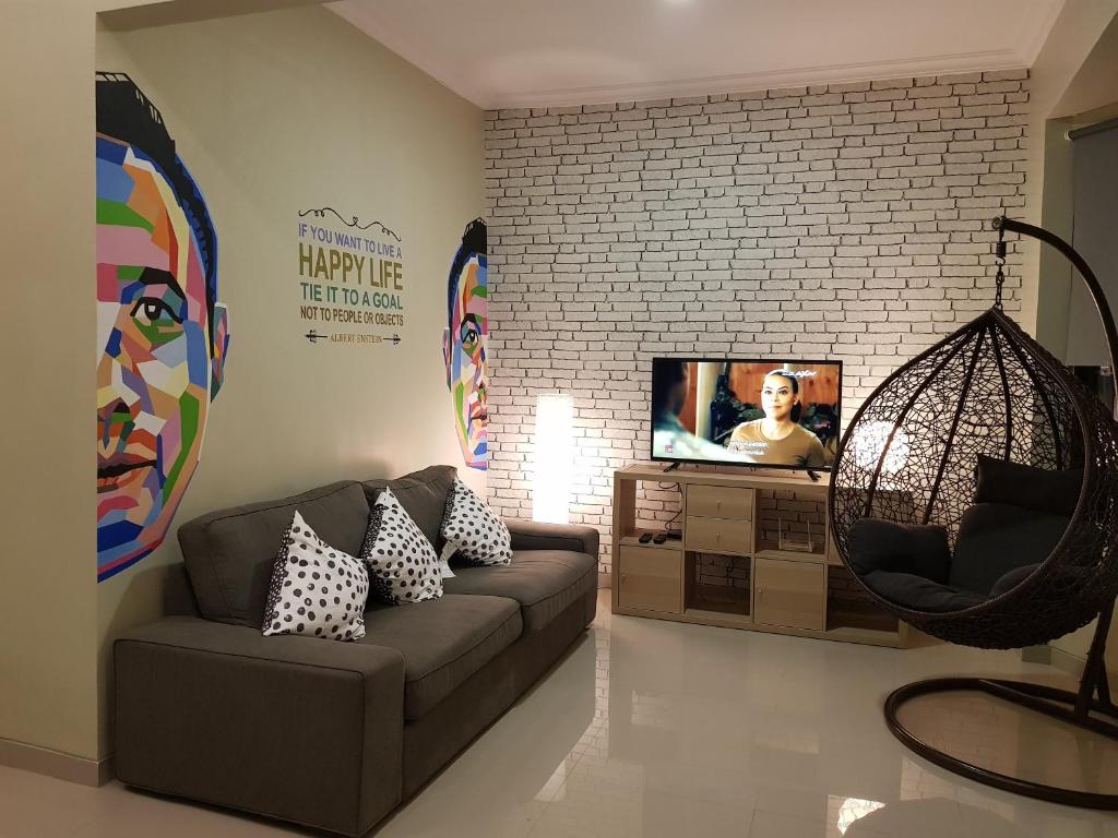 sala de estar con sofá y TV en Danka@tudor residence, en Batam Centre