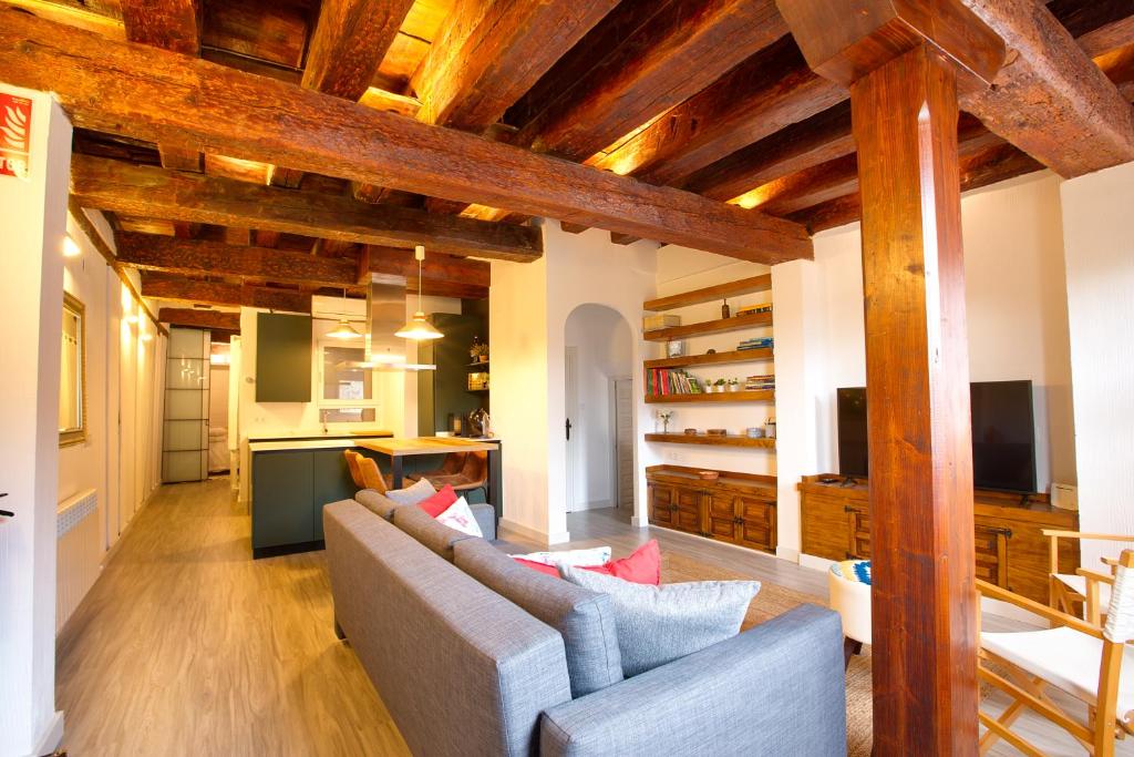 sala de estar con sofá y cocina en Cuencaloft Vigas del Sire, en Cuenca