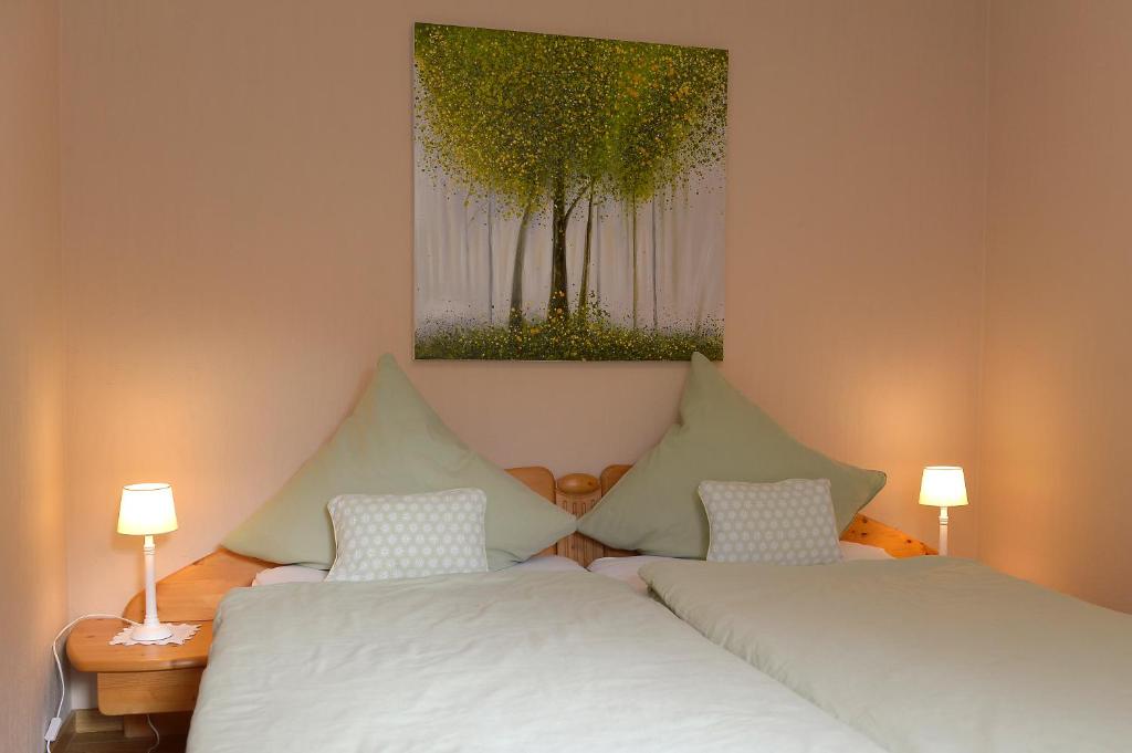 2 Betten in einem Zimmer mit einem Bild an der Wand in der Unterkunft Ferienwohnung Wagner 4 Sterne in Neef