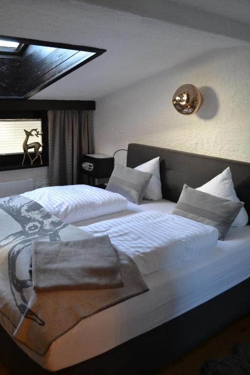 een slaapkamer met 2 bedden en witte lakens bij Andys Bergjuwel in Leutasch