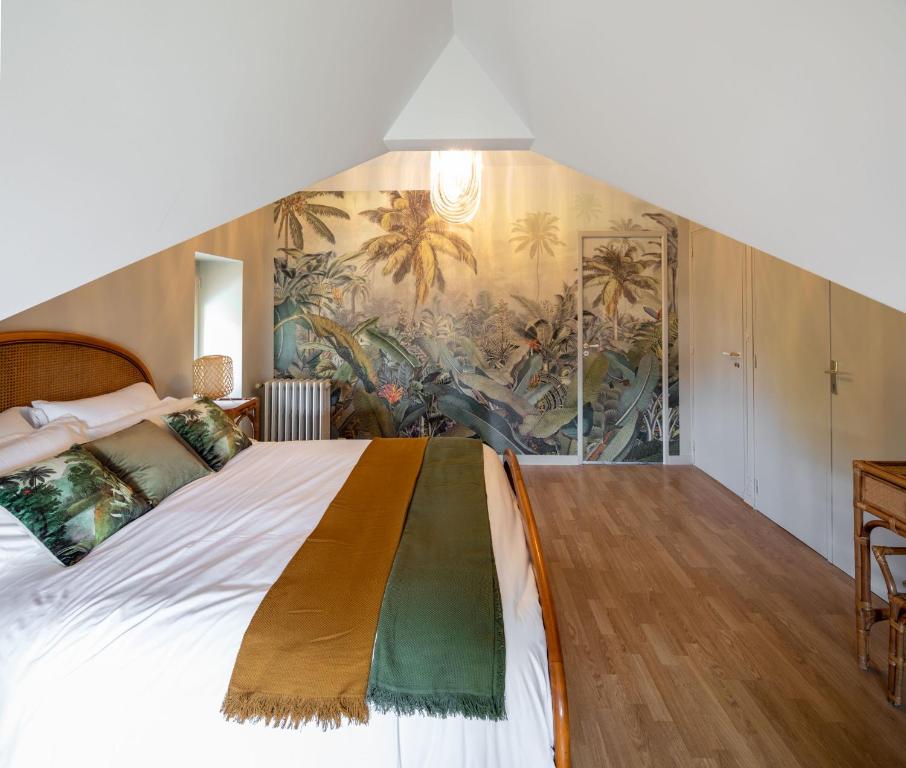 um quarto com uma cama grande e um mural na parede em La Maison de Florence em Angers