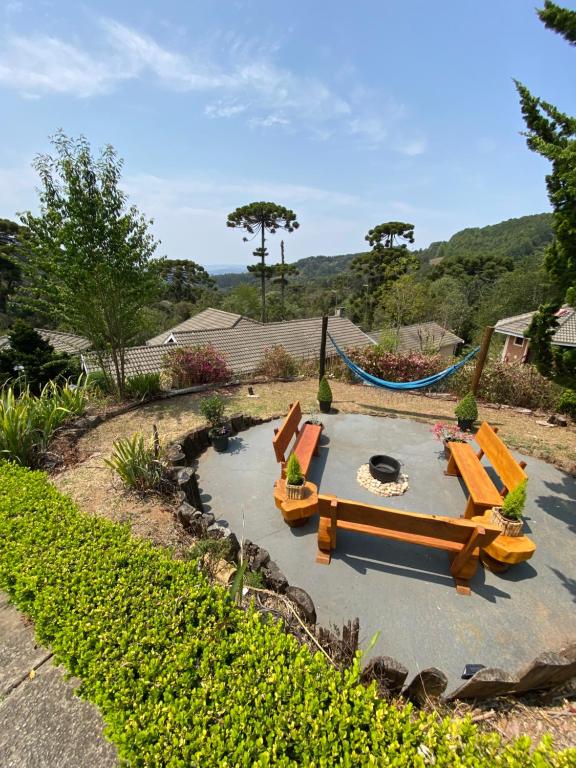 a backyard with a pond with benches and a hammock at Pousada 3 Pinheiros in Campos do Jordão