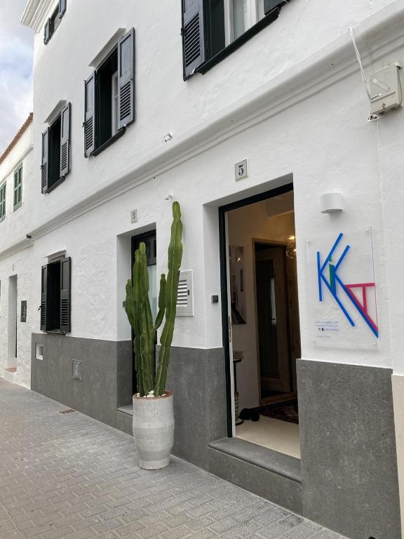 a building with a door and a cactus in front of it at Ca na Kika 5 in Es Migjorn Gran