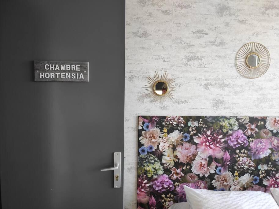 een slaapkamer met een muurschildering van bloemen op de muur bij Chambre HORTENSIA in Questembert
