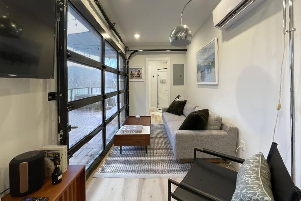 ein Wohnzimmer mit einem Sofa und einem TV in der Unterkunft The Hideaway on Tacketts - Shipping Container in Hurricane