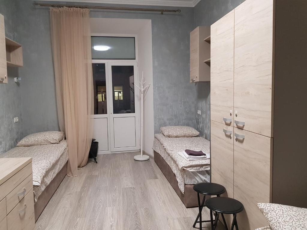 a room with two beds and a door with two stools at Hostel "Гном & Gnome" in Lviv