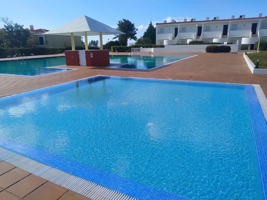 a large blue swimming pool in front of a building at 8 1 Figueirinhas - Casas & Papéis in Armação de Pêra