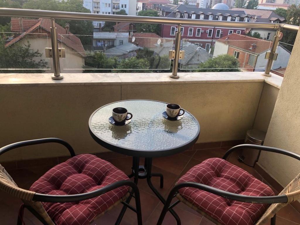 a table and two chairs with coffee cups on a balcony at Ana Studio 307 in Prishtinë