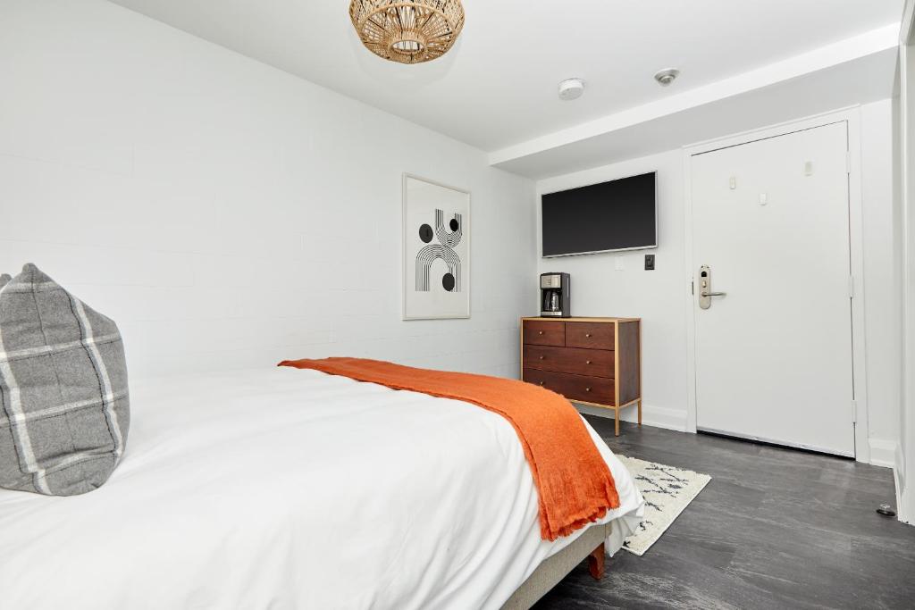 1 dormitorio blanco con 1 cama y TV en Sonder The Wellesley, en Toronto