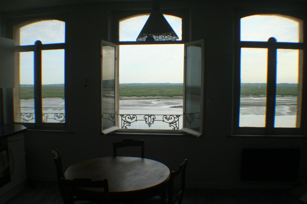 サン・ヴァレリー・シュル・ソンムにあるResidence des Quaisの窓3つ(テーブル、椅子付)が備わる客室です。
