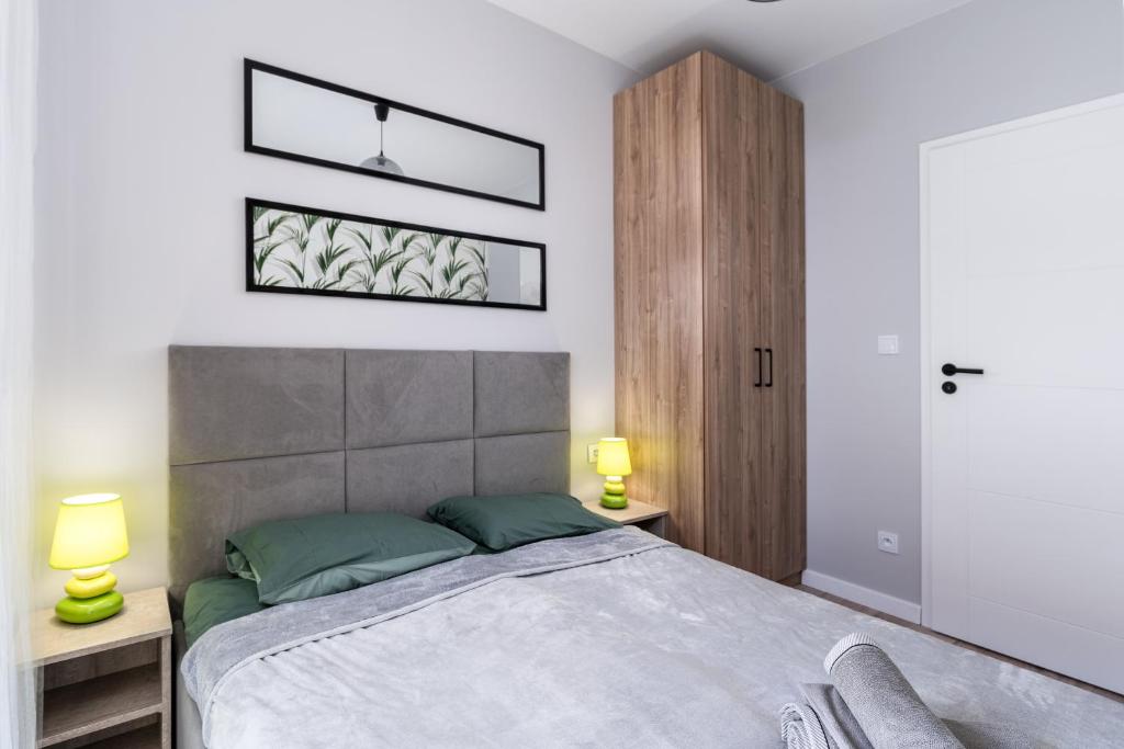 ein Schlafzimmer mit einem großen Bett und zwei Lampen in der Unterkunft Dąbska Street Krakow - Luxury Apartments in Krakau