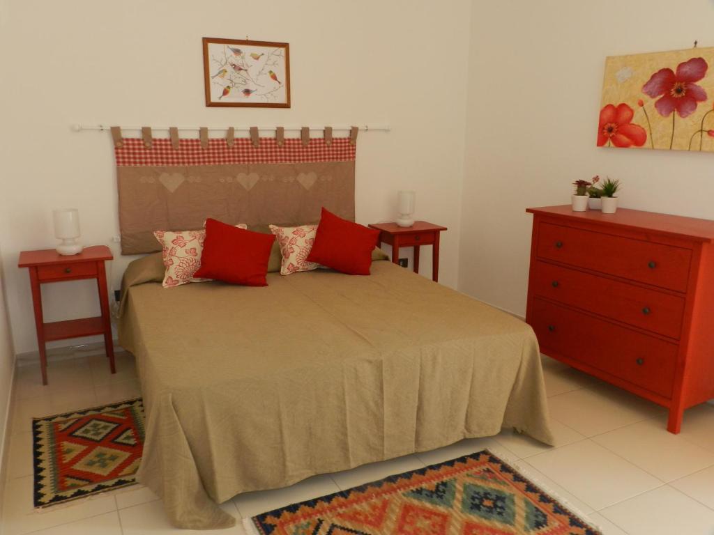 1 dormitorio con 1 cama con almohadas rojas y vestidor en Orleans Apartments, en Palermo