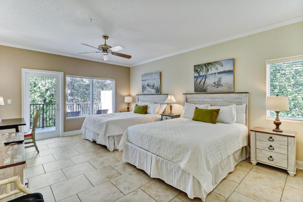 two beds in a room with two windows at Dog-Friendly Tennis Villa Suite in Amelia Island w/Shared Pool, Free WiFi in Fernandina Beach