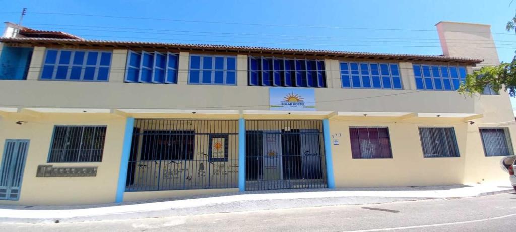 um edifício com janelas azuis e portões numa rua em SOLAR HOSTEL PARNAIBA na Parnaíba