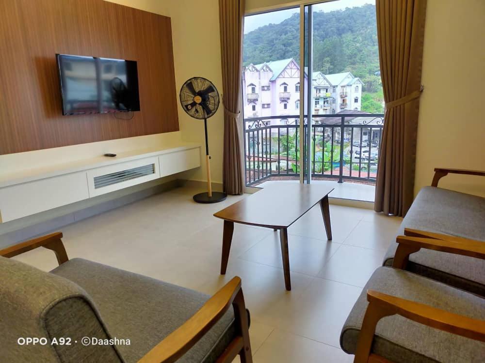 a living room with a couch and a table and a tv at CAMERON TROPICA HOMESTAY in Cameron Highlands