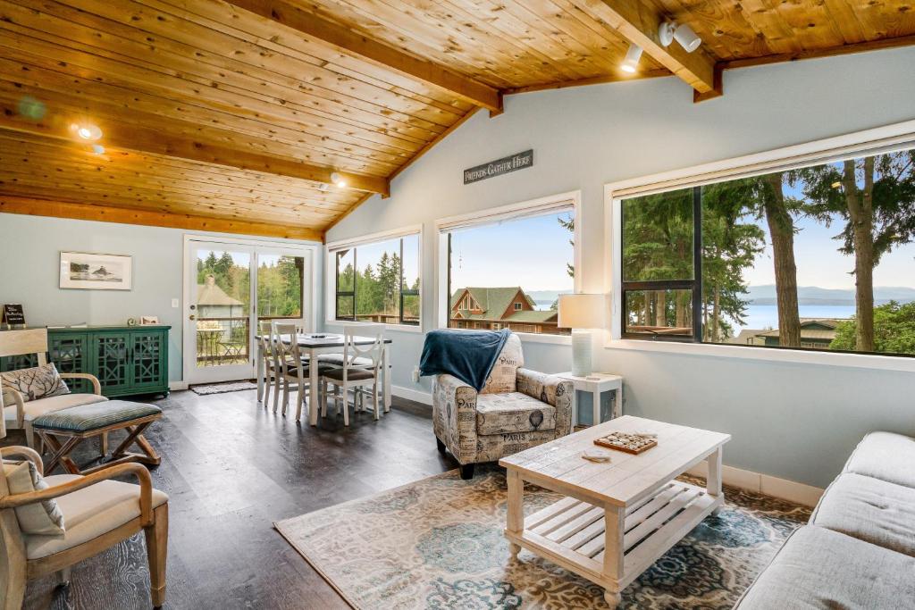 a living room with a wooden ceiling and windows at Blue Heron Lookout in Freeland