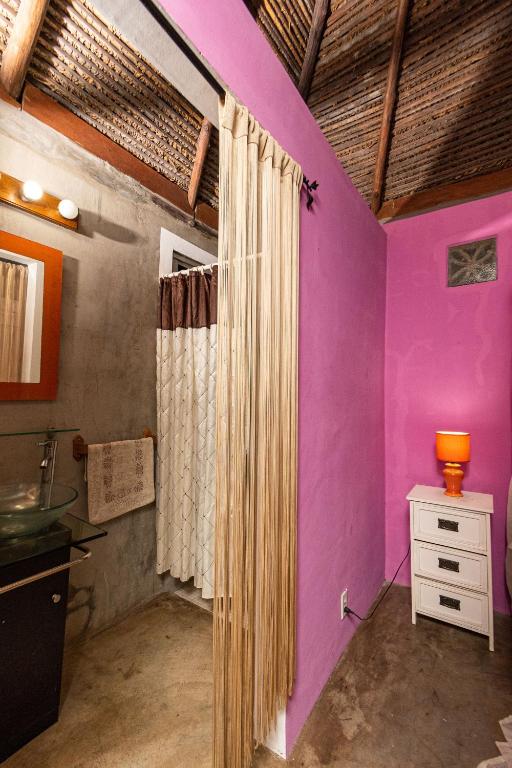 a bathroom with pink and purple walls and a sink at Monkey Lodge Panama in Chilibre