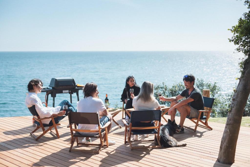 un grupo de personas sentadas en sillas cerca del océano en Sameya - Vacation STAY 80909v, en Sumoto