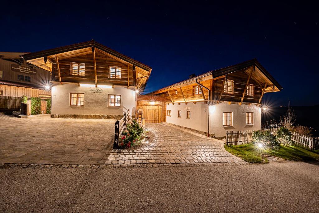 une grande maison avec deux bâtiments la nuit dans l'établissement Alm-Chalets-Samerberg, à Samerberg