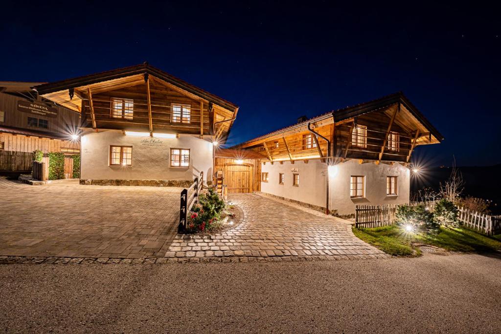 a large house with two buildings at night at Alm-Chalets-Samerberg in Samerberg