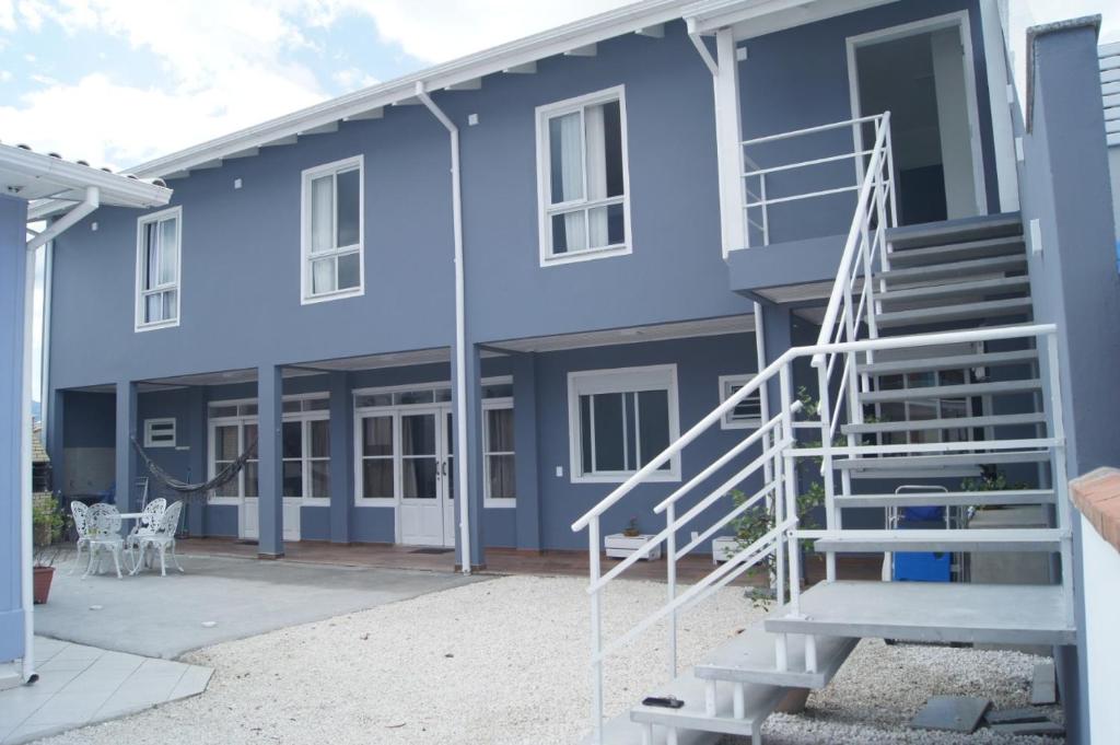 uma casa azul com escadas em frente em Casa com 2 quartos à 200 m da da praia c/ churrasqueira em Palhoça