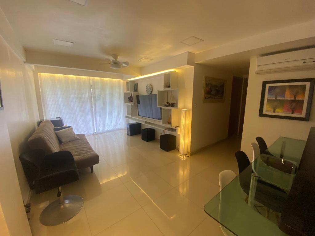 GUARAJUBA Condomínio PARAÍSO DOS CORAIS BEACH RESORT 132 في غوارايوبه: غرفة معيشة مع أريكة وطاولة