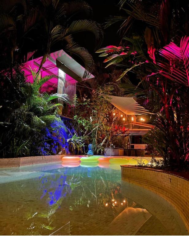 a swimming pool with lights in a garden at night at Monkey Lodge Panama in Chilibre