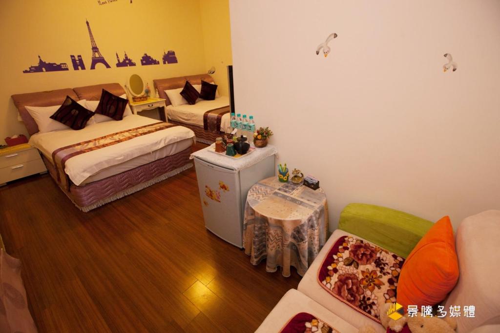 a small room with two beds and a couch at Hai Yang Feng Qing Homestay in Hualien City