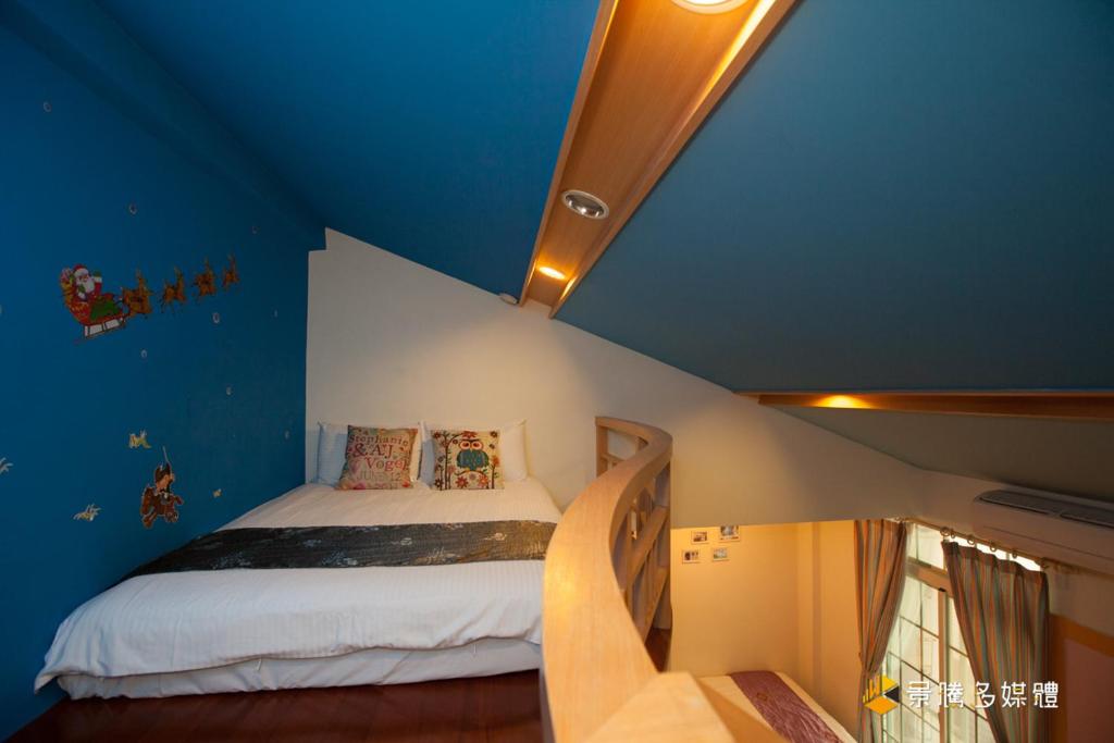 a bedroom with a bed in a blue room at Hai Yang Feng Qing Homestay in Hualien City