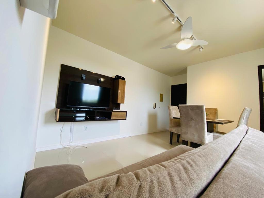 un soggiorno con divano e TV a parete di Apartamento Canabarro Residence a Uruguaiana