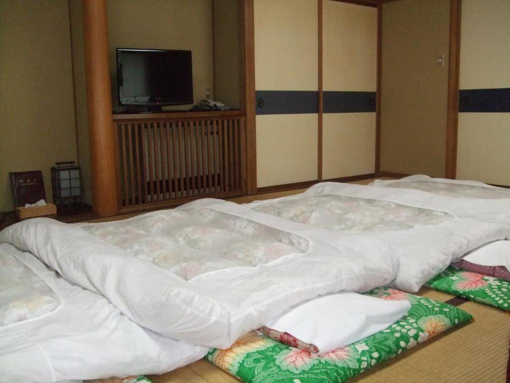 Postel nebo postele na pokoji v ubytování Marunaka Ryokan