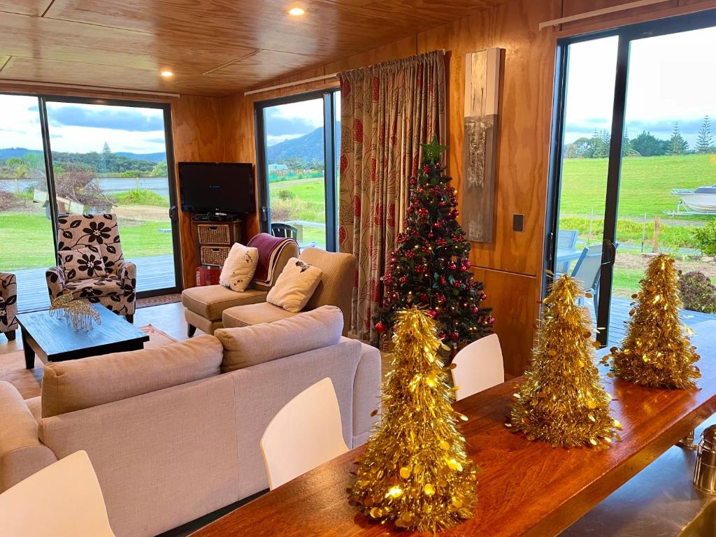 a living room with christmas trees in a room at The Camel at Araiawa Raio Lodge Pukenui in Pukenui