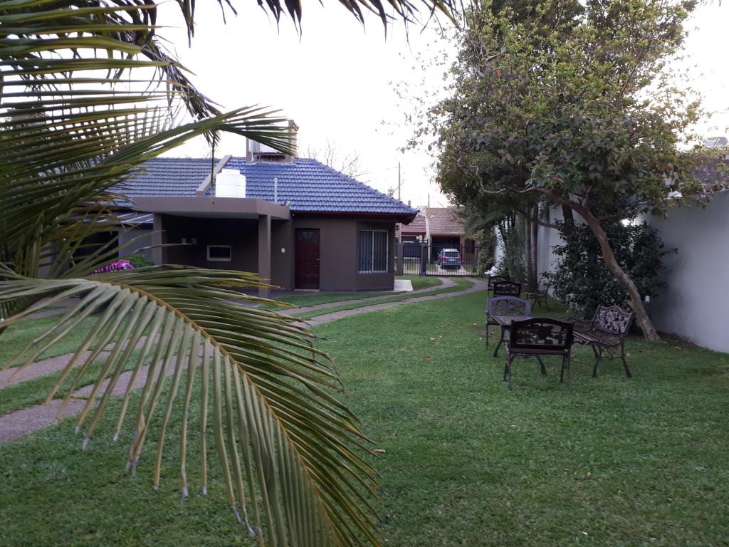 un patio con dos bancos frente a una casa en Alojamientos Estrellas Azules en Colón