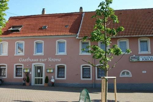 un edificio rosa con un árbol delante de él en Gasthaus zur Krone, en Feilbingert