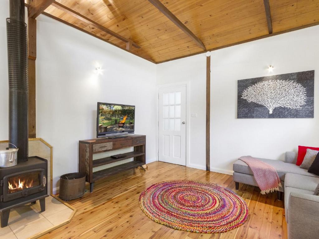 a living room with a fireplace and a couch at Blue Apple Lodge in Bilpin