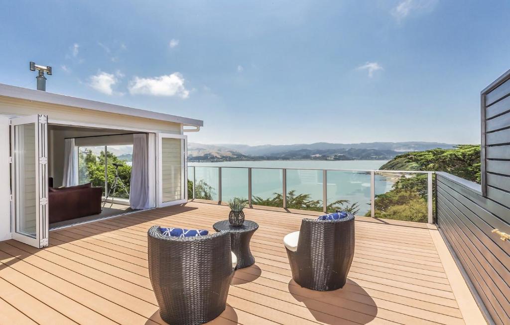 une terrasse en bois avec vue sur l'eau dans l'établissement Whitby sea view, à Porirua