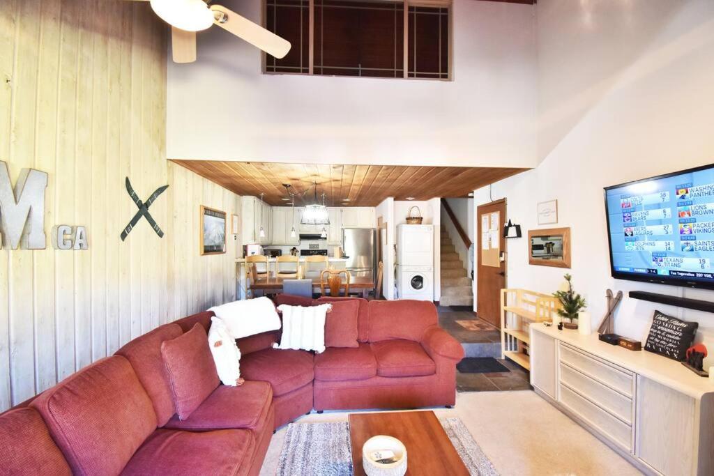 - un salon avec un canapé rouge et une télévision dans l'établissement COZY Condo at Canyon Lodge! Sleeps 8, a walk to Canyon Lodge, à Mammoth Lakes