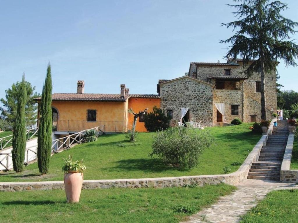 una gran casa de piedra con un patio delante en Belvilla by OYO La Quiete di Montalbano, en Città di Castello