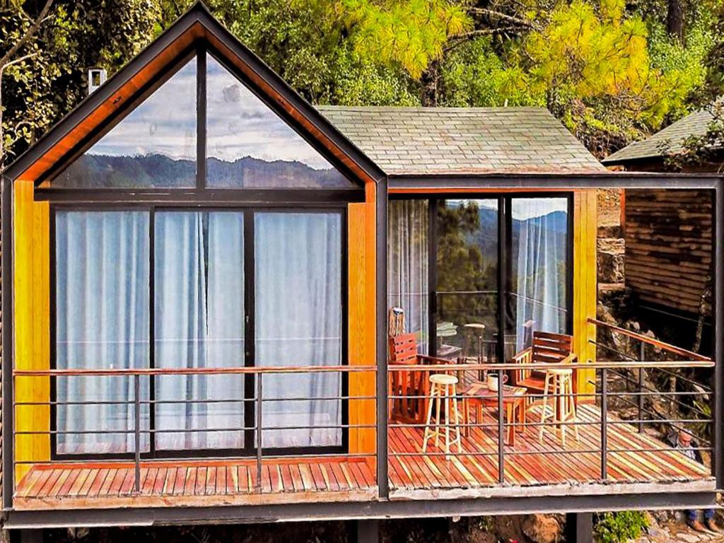 une cabine avec une grande fenêtre et une table sur une terrasse dans l'établissement Alto de la Sierra by Rotamundos, à El Pacífico