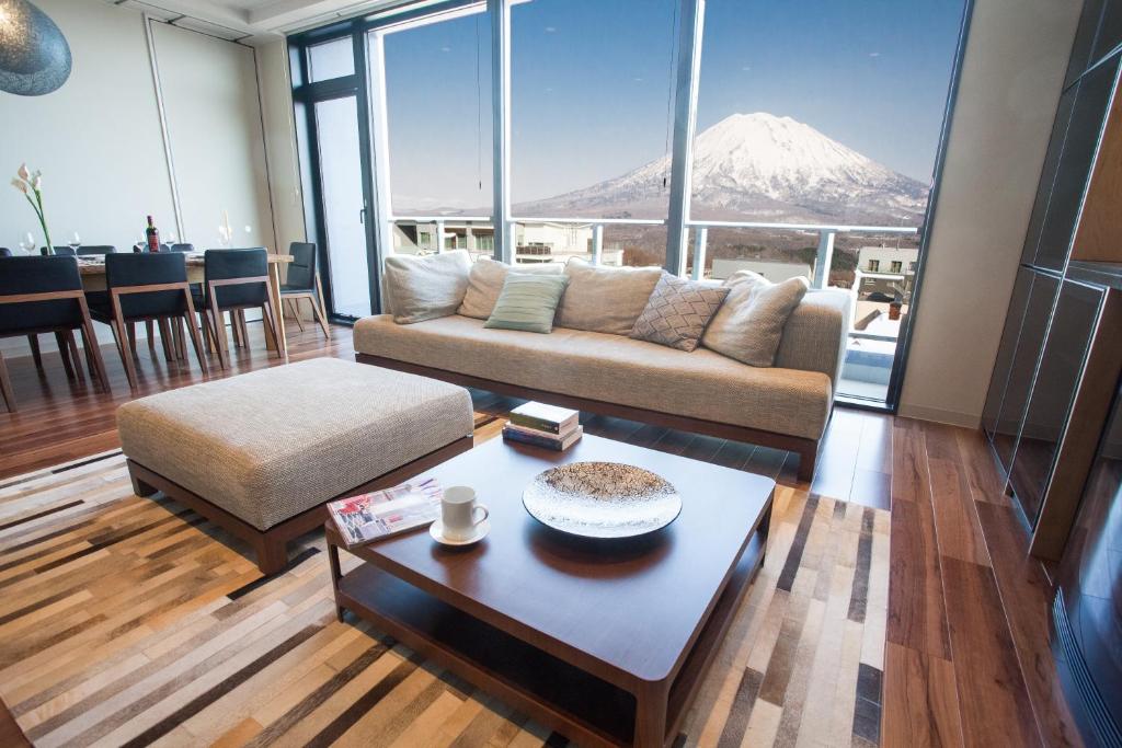 a living room with a couch and a table and a mountain at hirafu188 in Niseko