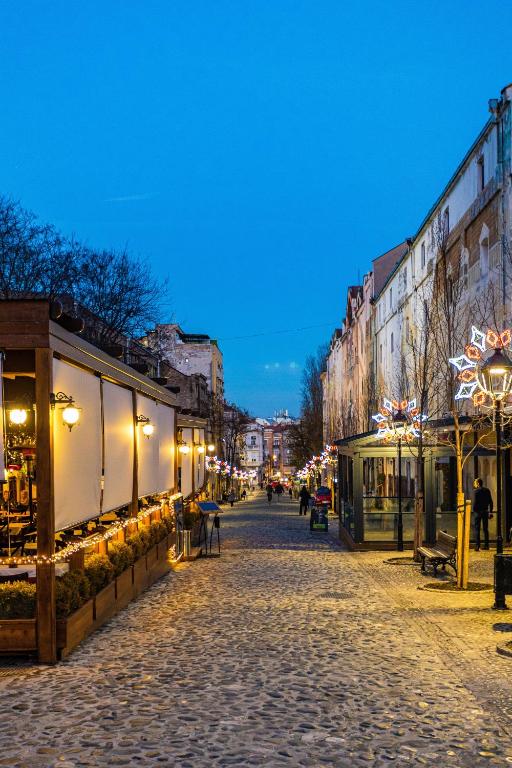 una strada di ciottoli in una città di notte di Traveling Actor a Belgrado