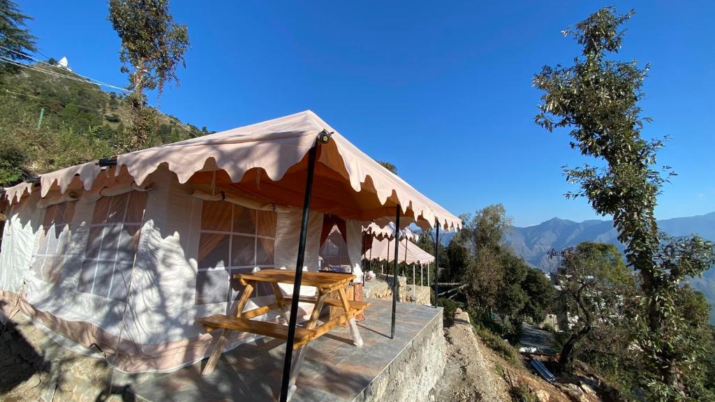ein kleines Zelt mit einem Tisch auf einem Berg in der Unterkunft Ananta Prana in Masuri